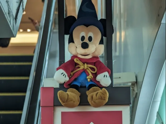 エスカレーターで座り待つミッキー（Disney THE MARKET）
